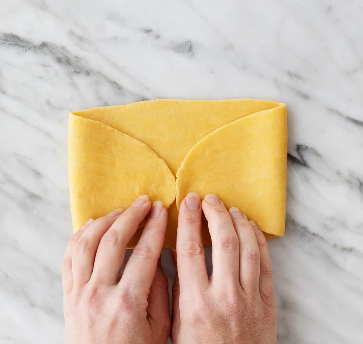 Folding ends of dough rectangle to meet in the middle