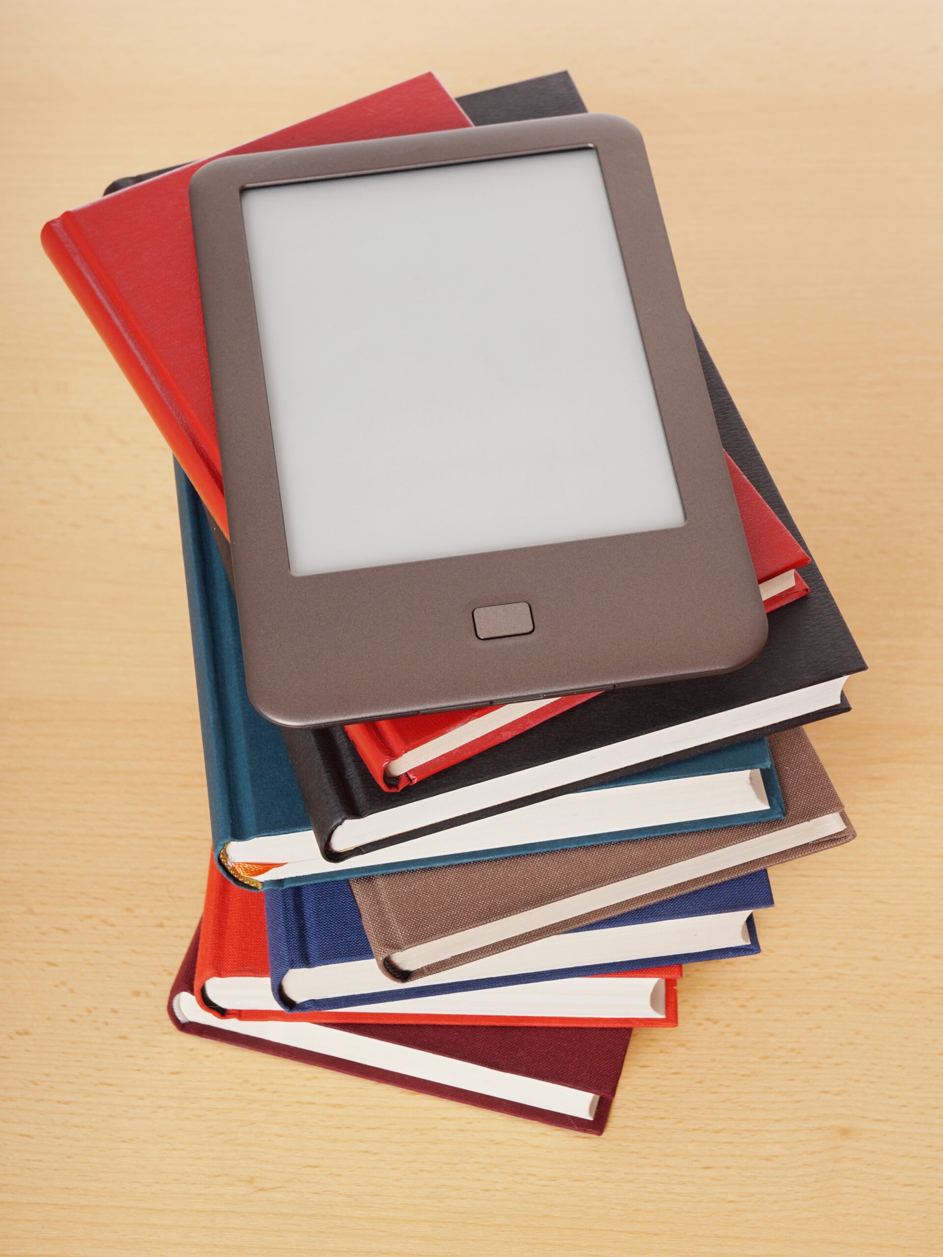 Printed books and e-book on a white background and glasses. The concept of modern technology and reading.