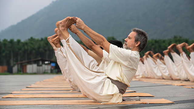 A group of meditators performing Ubhaya Padangushtasana