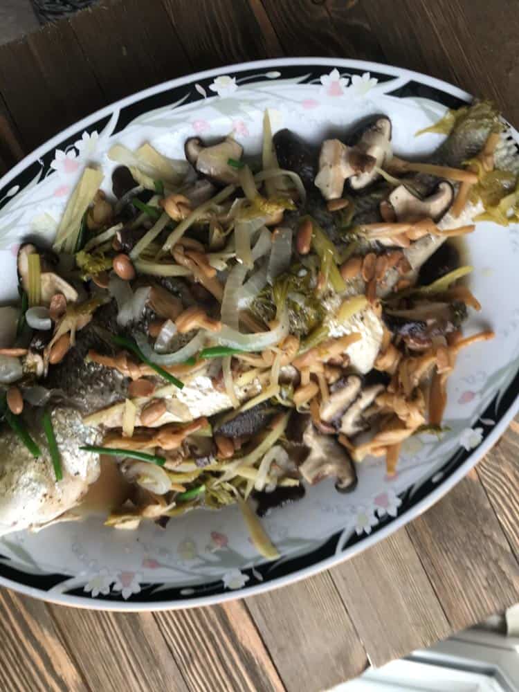 authentic vietnamese steamed whole fish with scallions, mushrooms, bamboo, onions